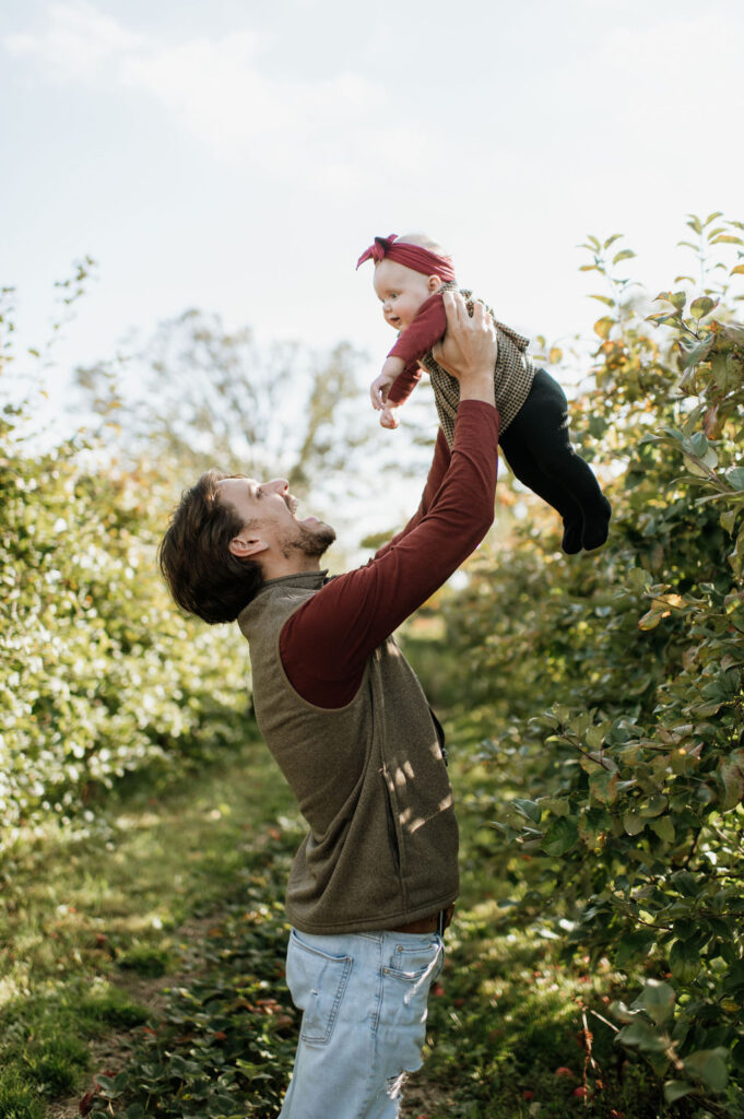 Father holding his baby daughter up in the air