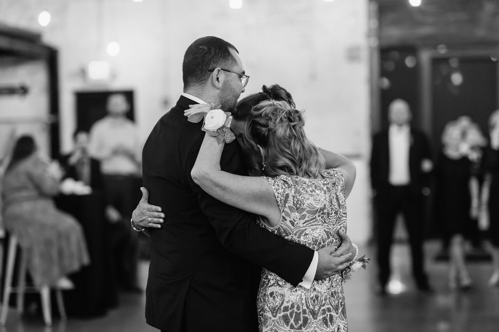 Groom dancing with his mother and step mother