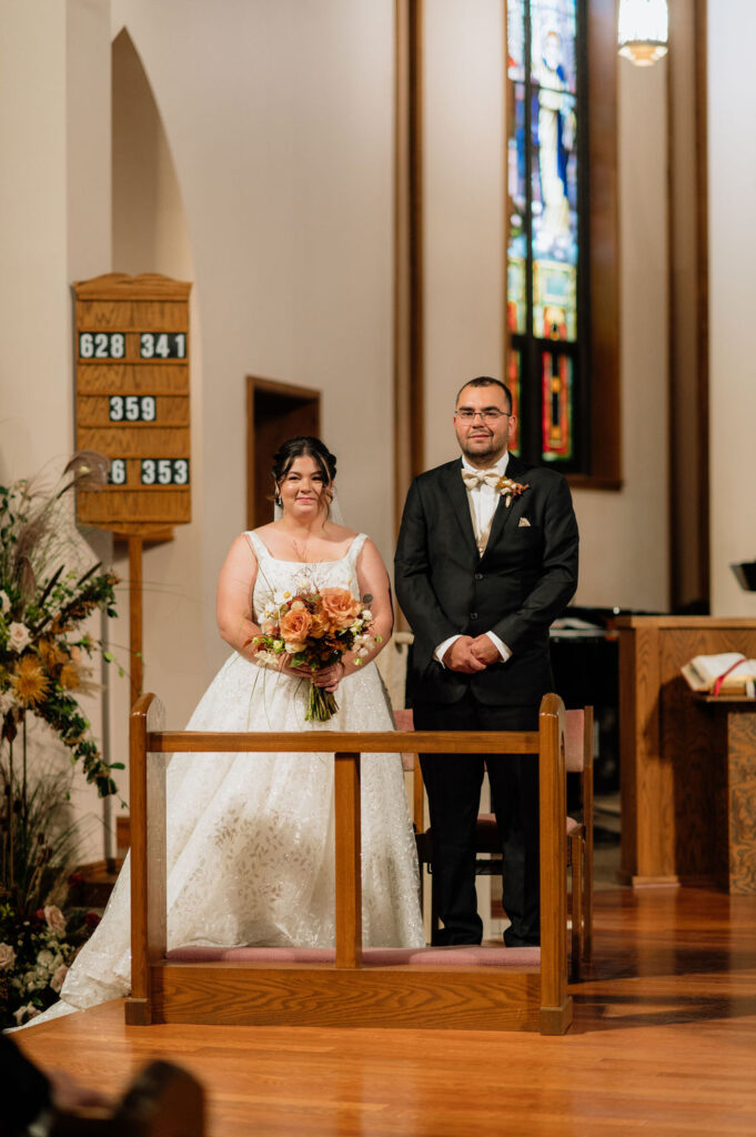 Fall indoor wedding ceremony at St. Bravo Catholic Church