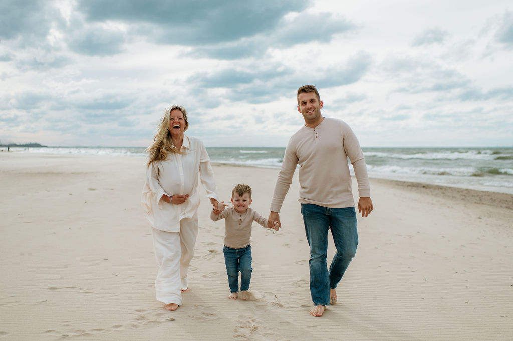 Family walking the beach at Indiana Dunes National Park for their family maternity photoshoot