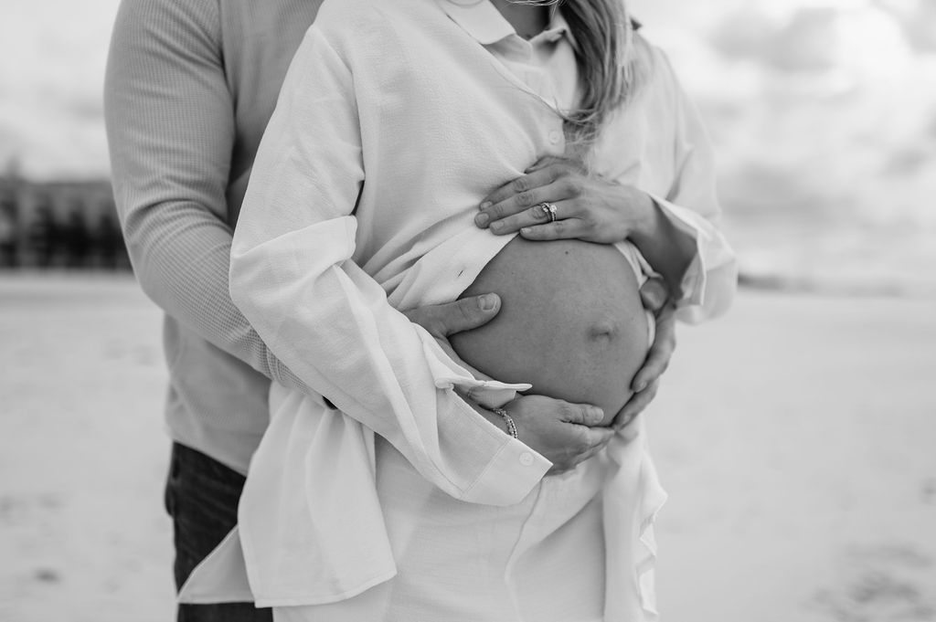 Man holding his wifes pregnant belly for maternity photos 