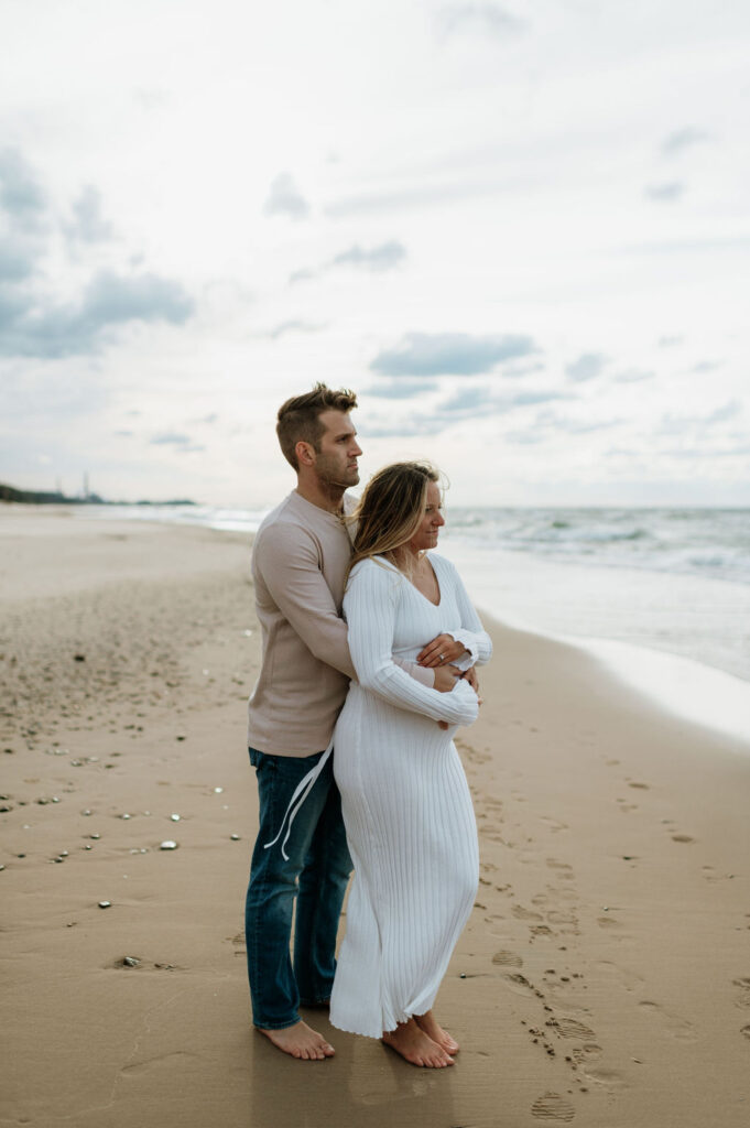Man and pregnant woman walking the beach