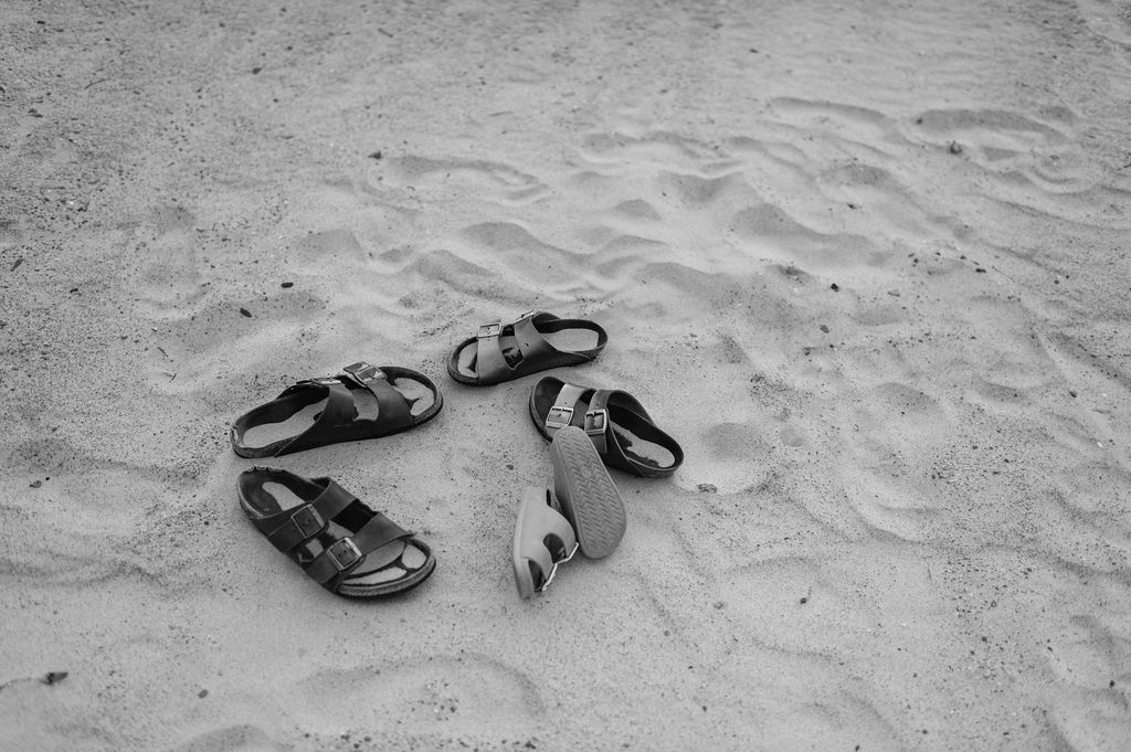 Family of threes sandals laying on the beach