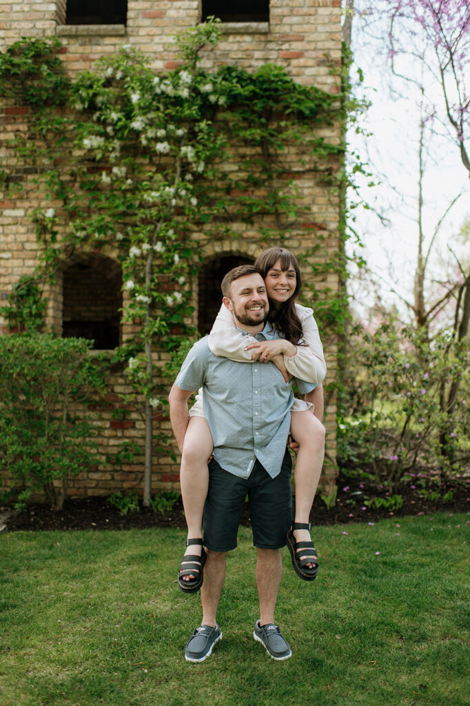 Man giving his fiancé a piggy back ride during their engagement session