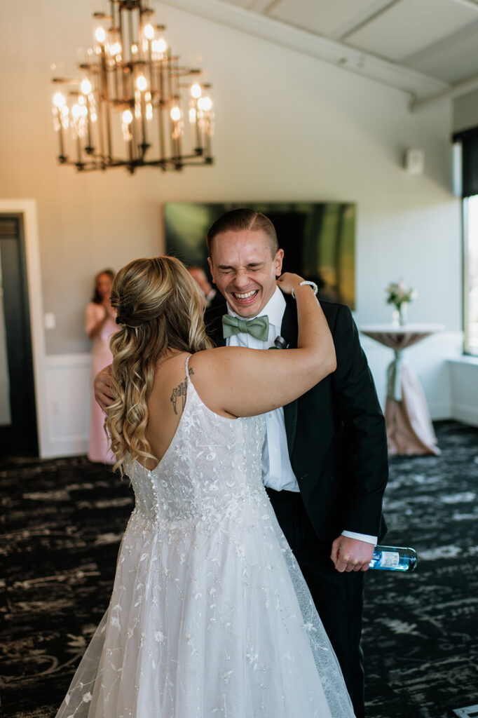 Bride hugging her brother as he's laughing because she just iced him.