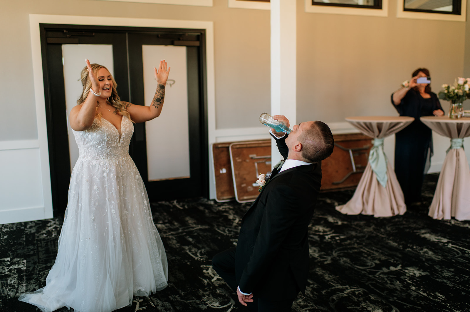 Bride cheering on her brother as he downs an ice cooler