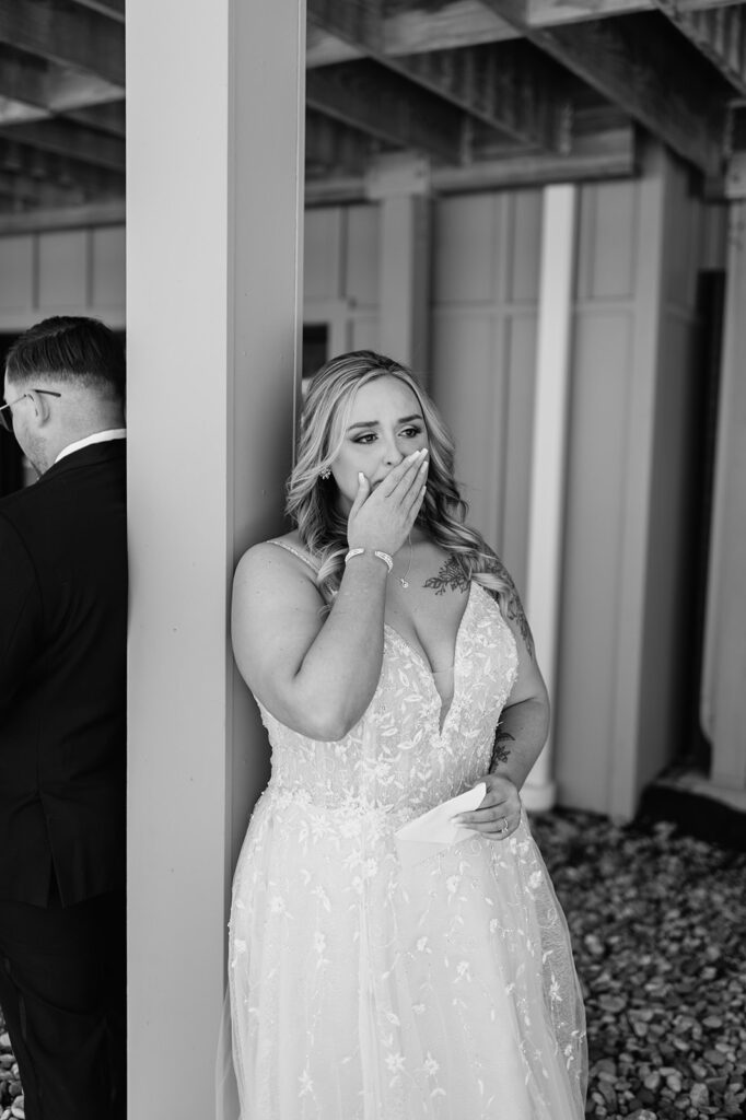 Black and white photo of a bride getting emotional while her groom reads private vows to her from their Morris Park Country Club wedding in South Bend, Indiana