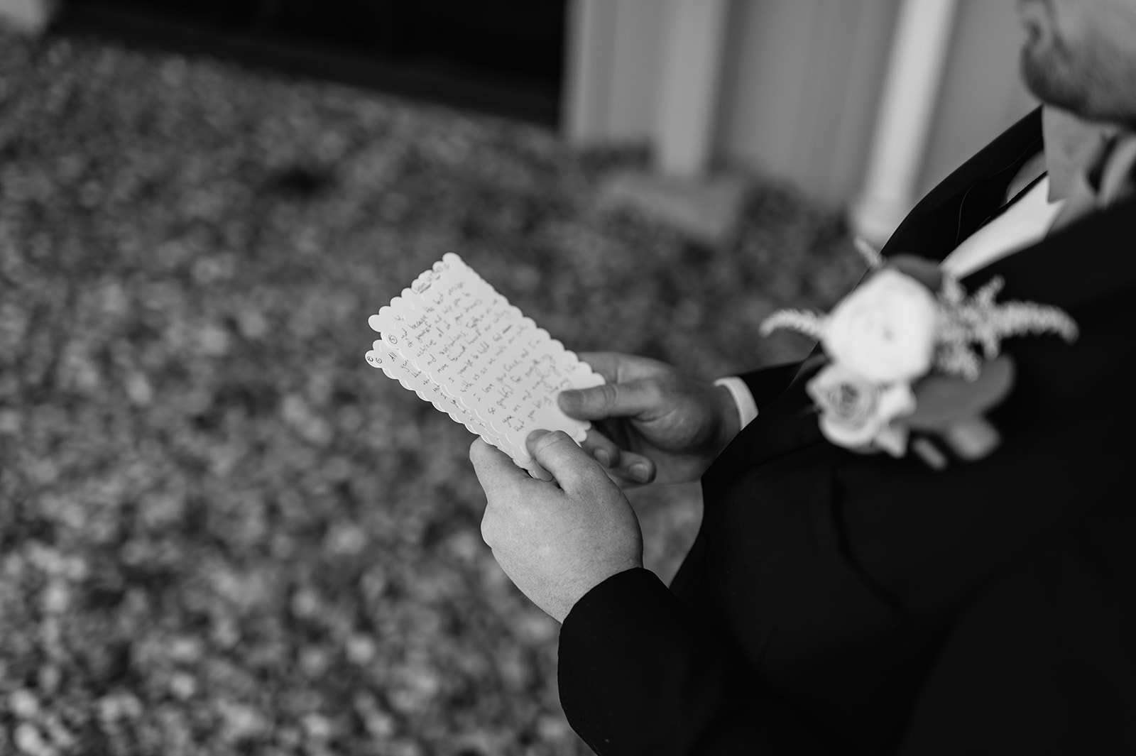 Close up black and white photo of a groom reading his private vows to his bride from their Morris Park Country Club wedding in South Bend, Indiana