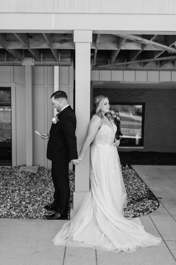 Black and white photo of a bride and groom holding hands as they exchange private vows to one another from their Morris Park Country Club wedding in South Bend, Indiana