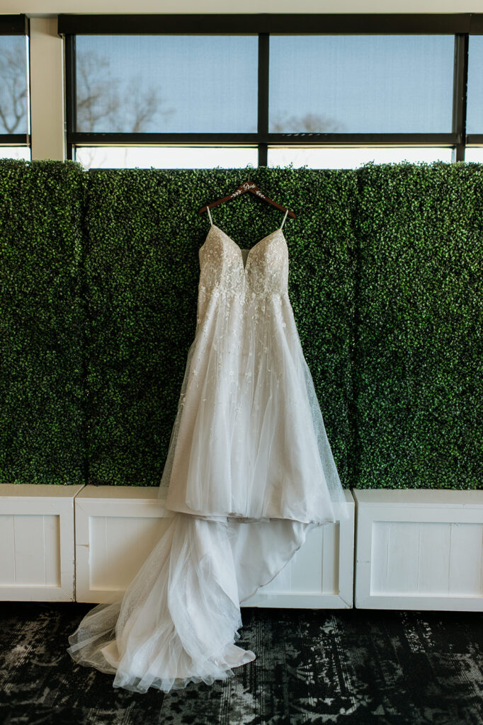 Brides wedding dress hanging from a hedge planter