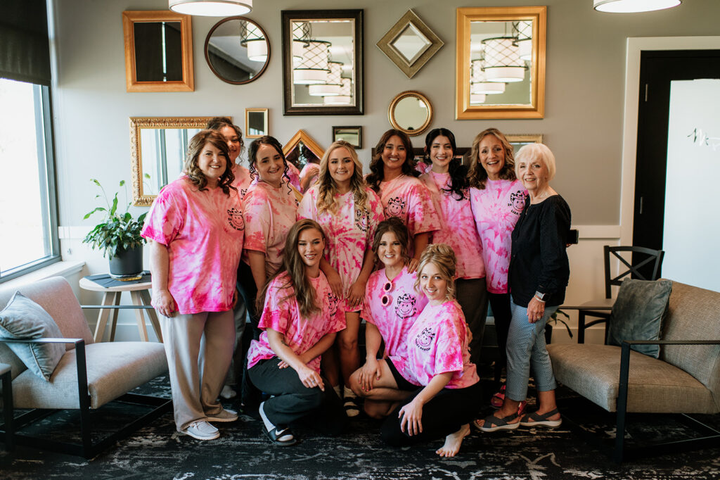 Bride and her bridesmaids wearing matching pink tie dye shirts