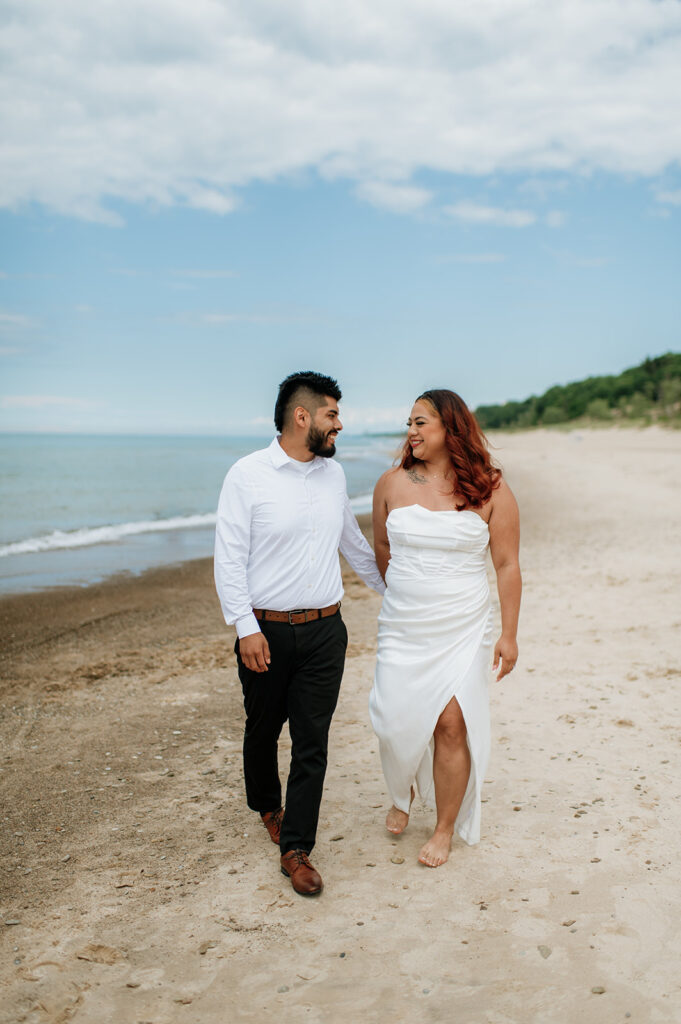 Bride and groom walking along the shoreline of Indiana Dunes National Park for their elopement in Indiana