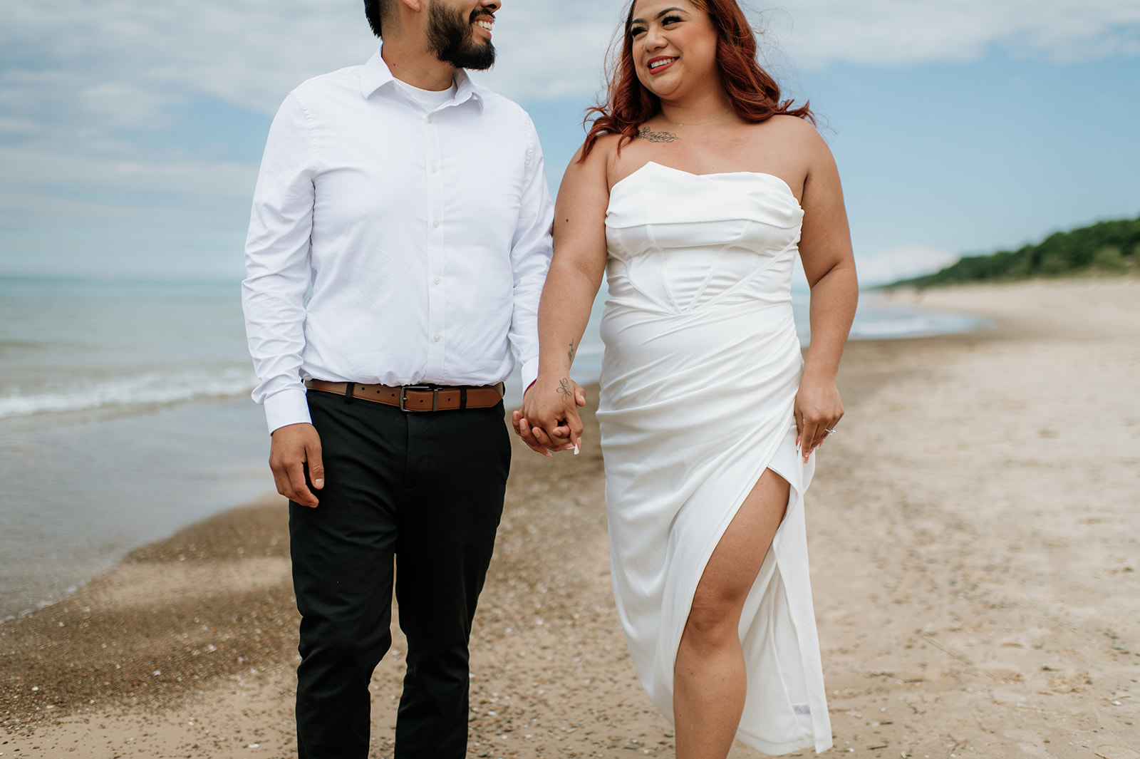 Bride and groom walking along the beach and holding hands during their elopement in Indiana