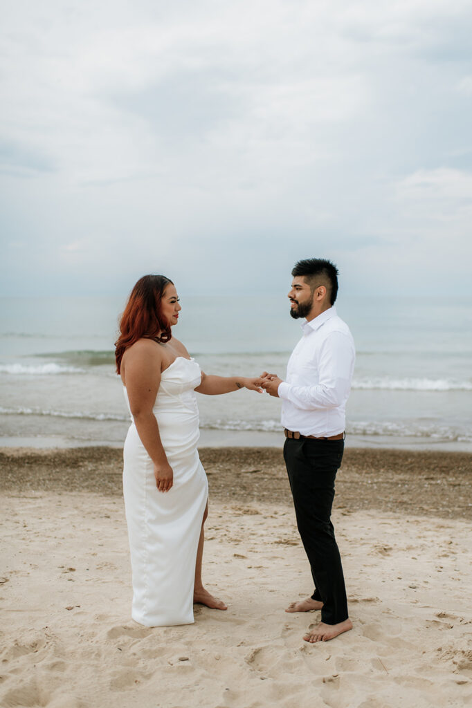 Bride and groom holding hands on the beach