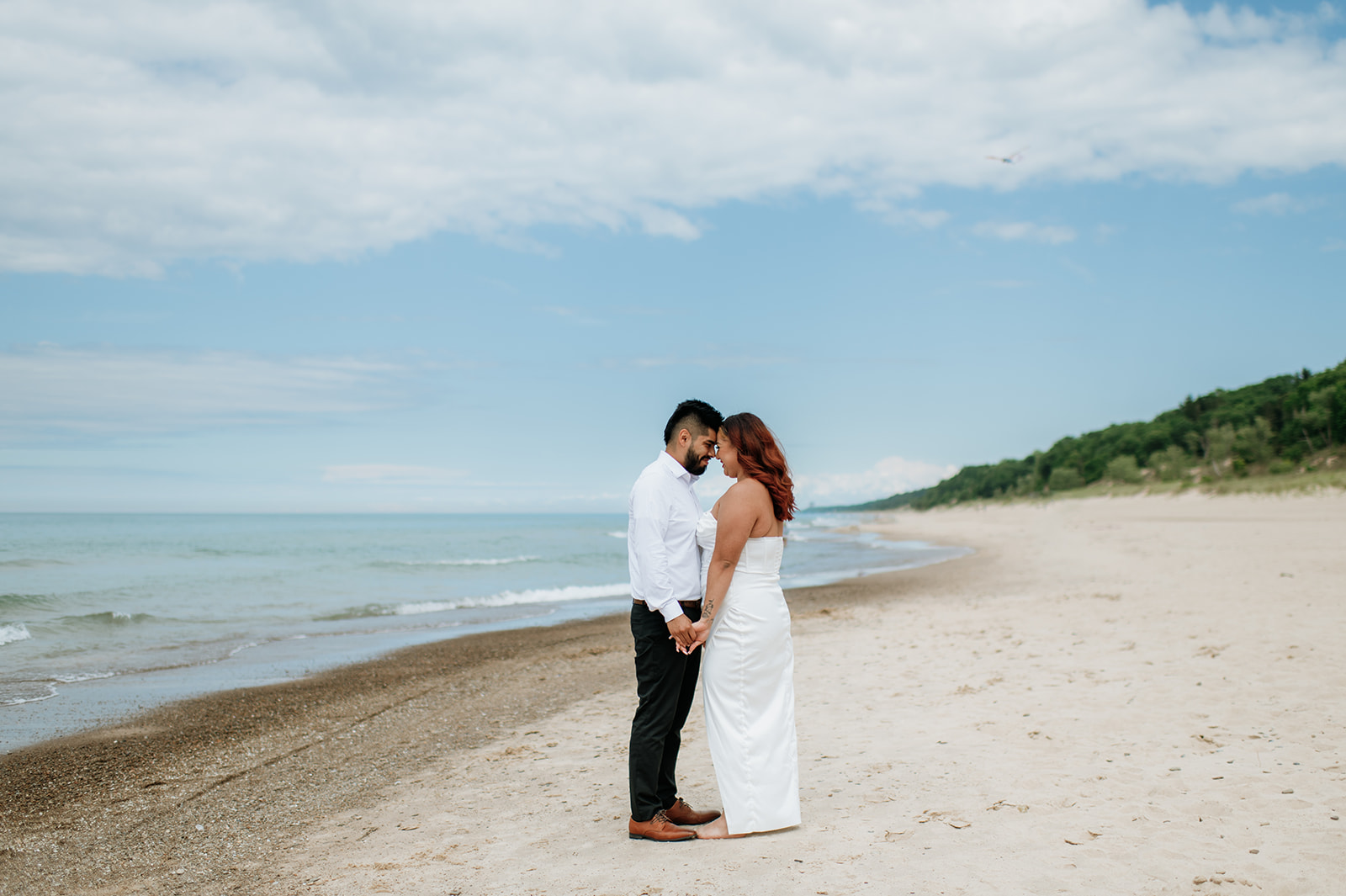 Bride and groom holding hands on the beach during their Indiana elopement