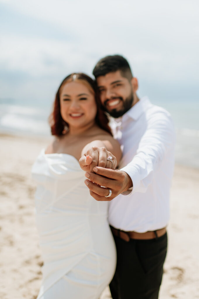 Bride and groom showing off their rings from their elopement in Indiana on the bach