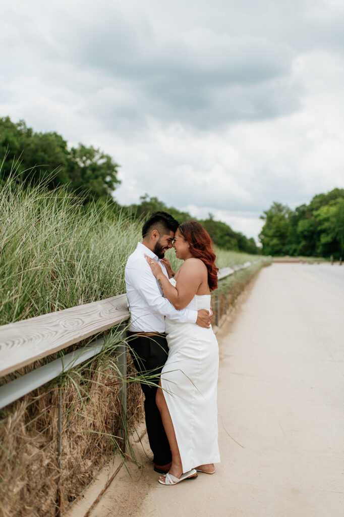 Bride and groom leaning against a fence for pottraits