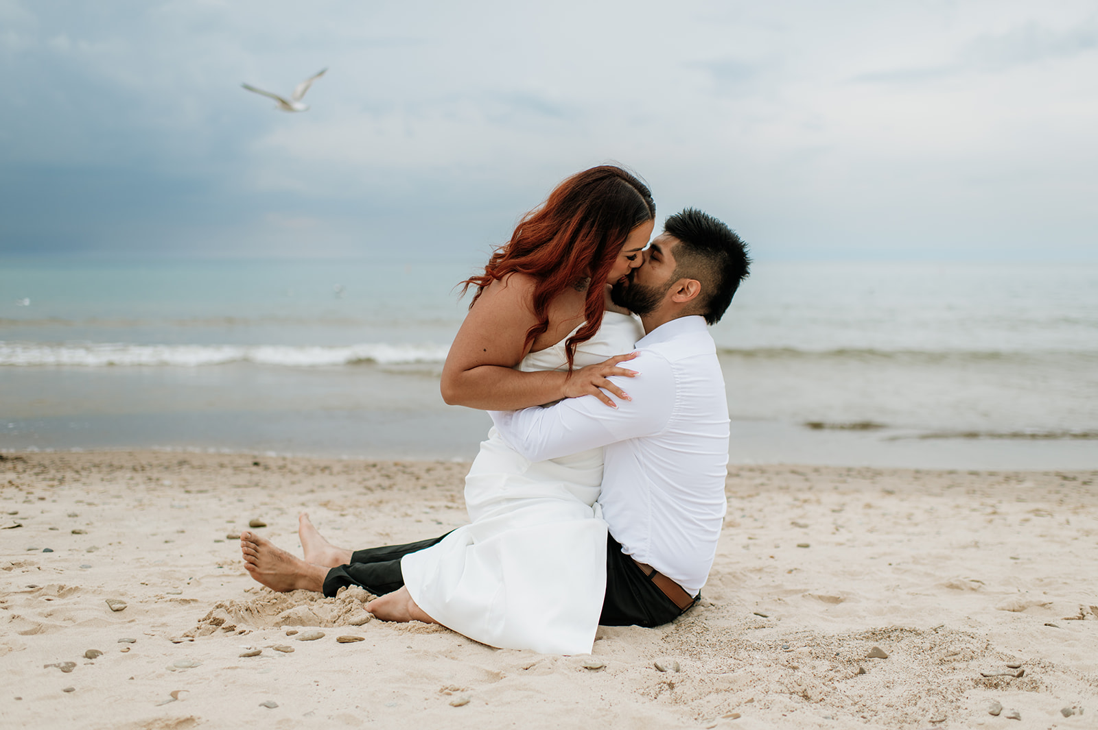 Bride kissing her groom on the beach during their intimate summer elopement