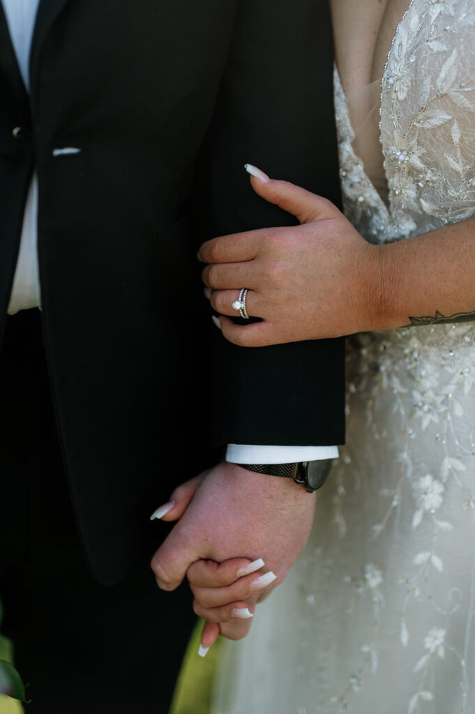 Close up shot of a bride and groom holding hands