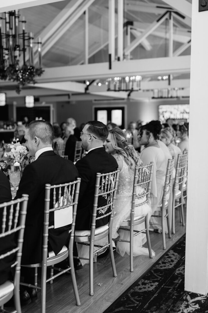 Black and white photo of a bride and groom during wedding speeches