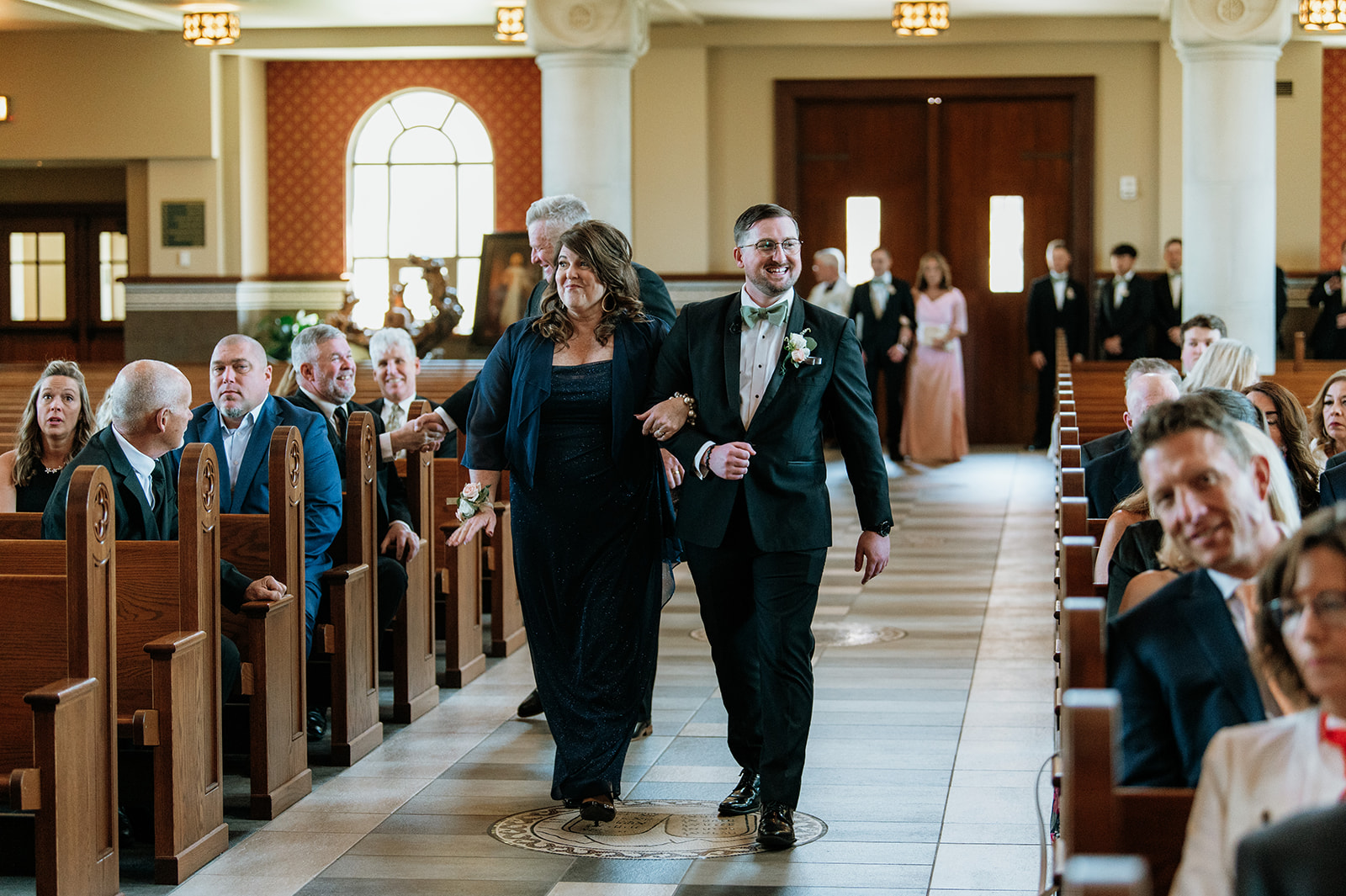 Groom and his parents walking down to the altar