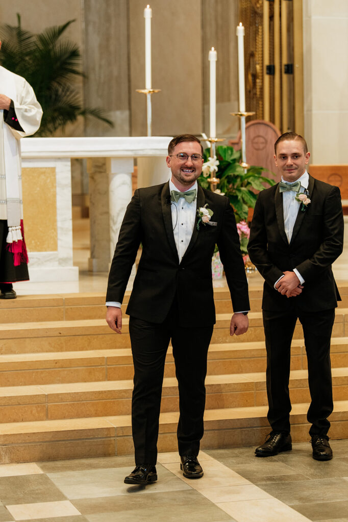 Groom excited to see his bride for the first time as she walks down the aisle