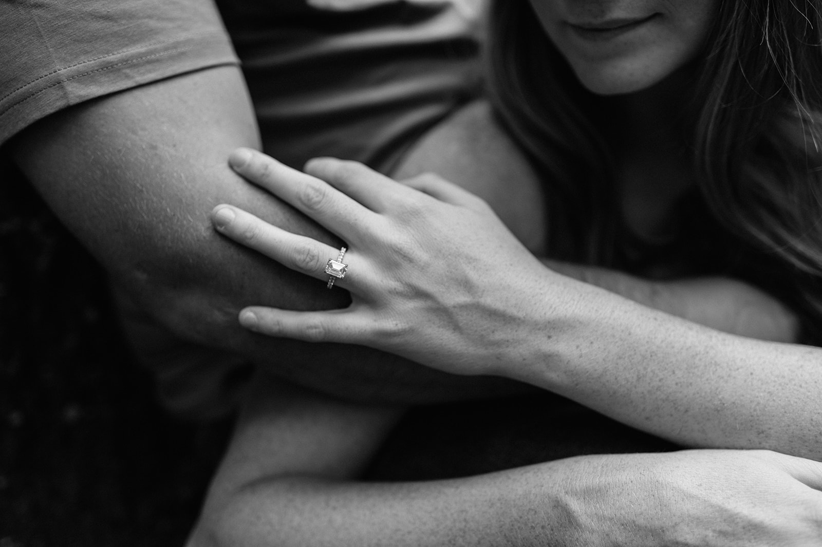 Black and white photo of a couple showing of an engagement ring