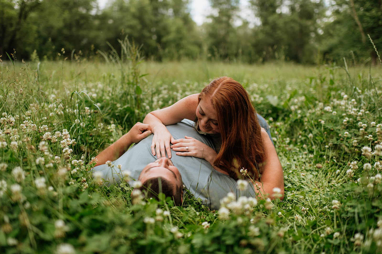 Woman resting on a mans chest for their engagement photos in Indiana