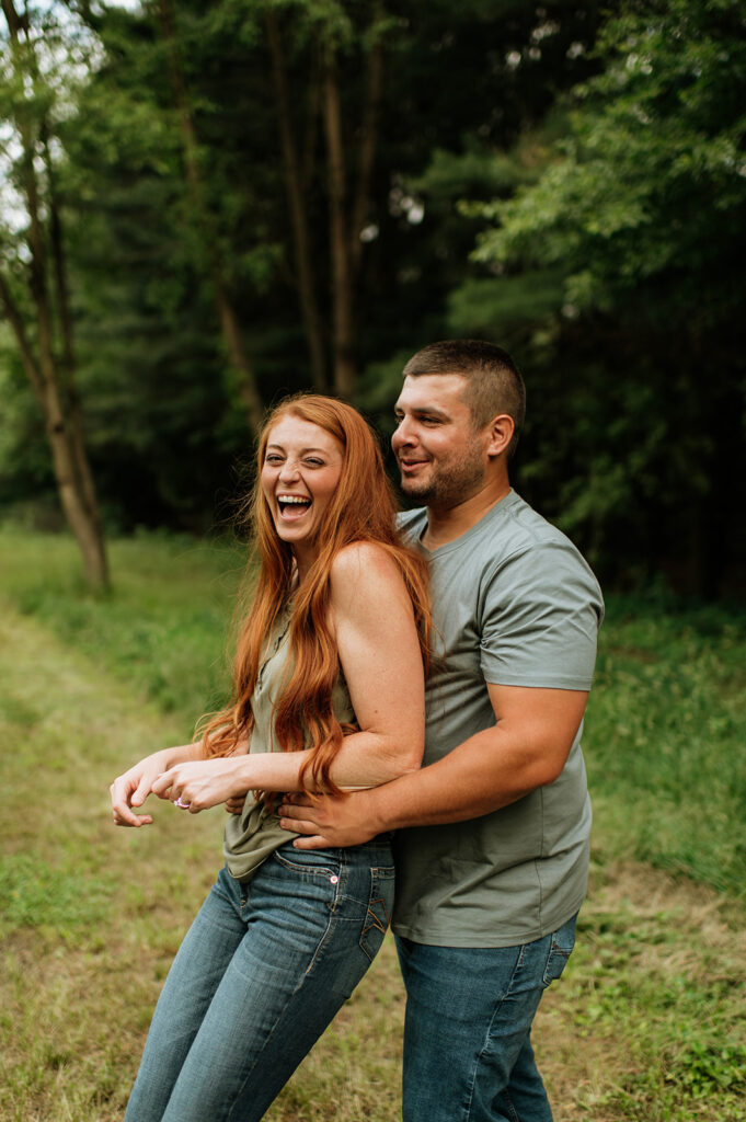 Couple being playful during their outdoor summer engagement photos in Indiana