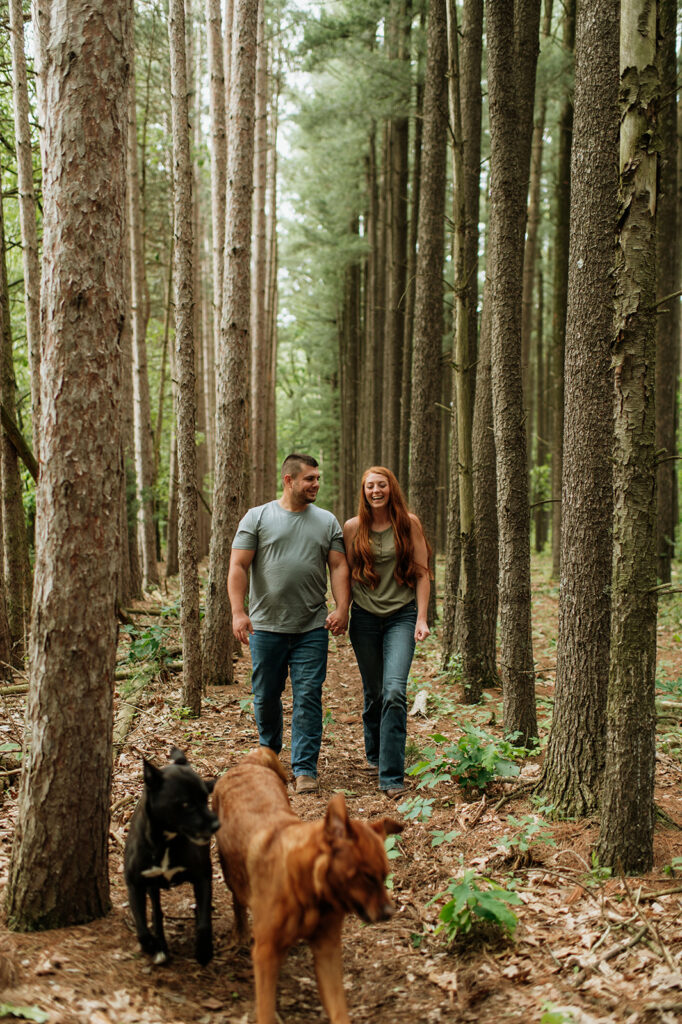 Couple walking in the woods for their outdoor summer engagement photos in Indiana