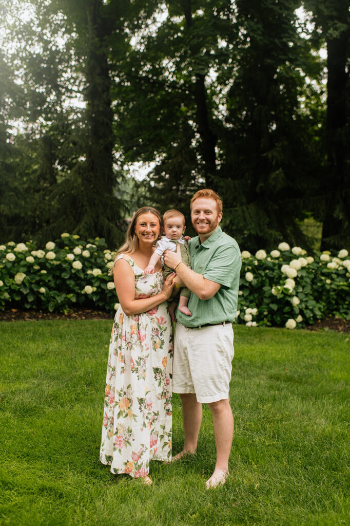 Family of three posing for their Lake Michigan family photos at their family lake house in Holland