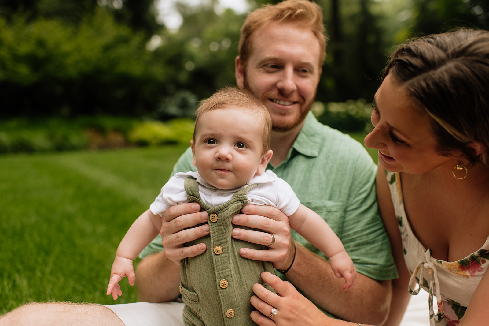 Baby boy looking in the camera during his Lake Michigan family photos with his mother and father