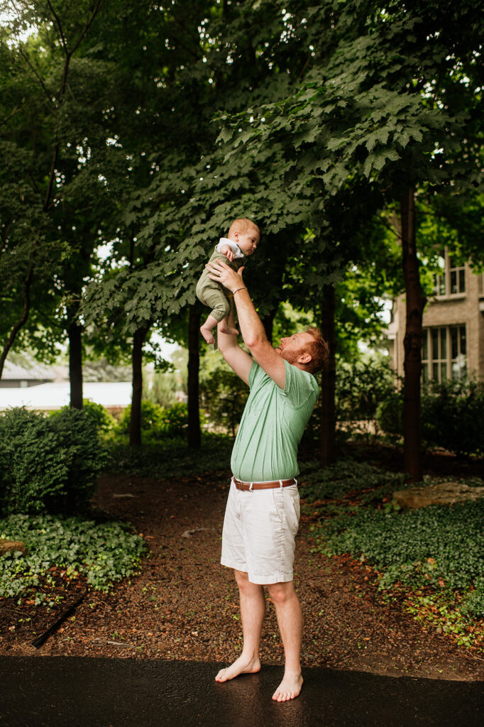 Father throwing his son in the airplay fully during their Lake Michigan family photos at their family lake home in Holland