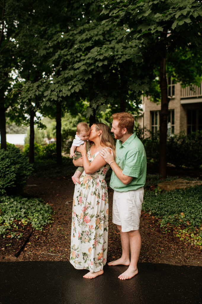 Mother and father posing with their baby during their Lake Michigan family photos at their family lake home in Holland