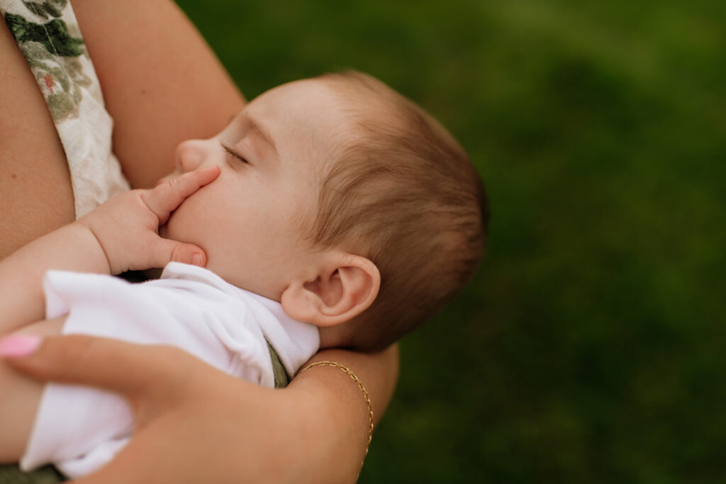 Baby boy taking a nap in his mothers arms