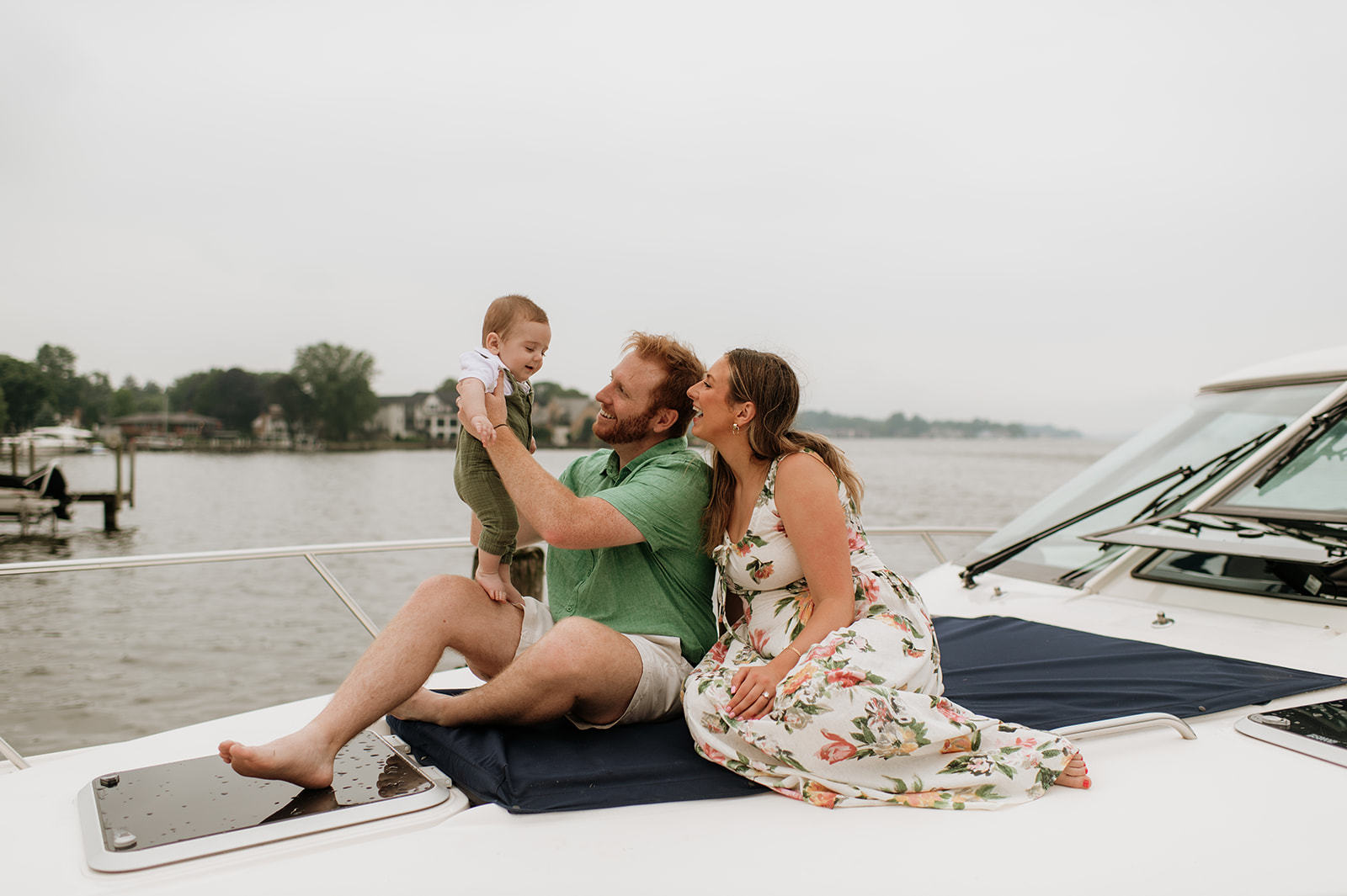 Family of three sitting on a boat for their Lake Michigan family photos in Holland