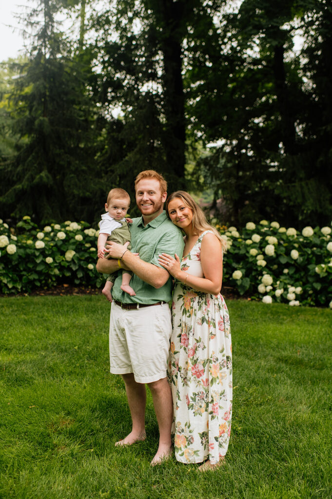 Family of three posing for their Lake Michigan family photos at their familylake home in Holland