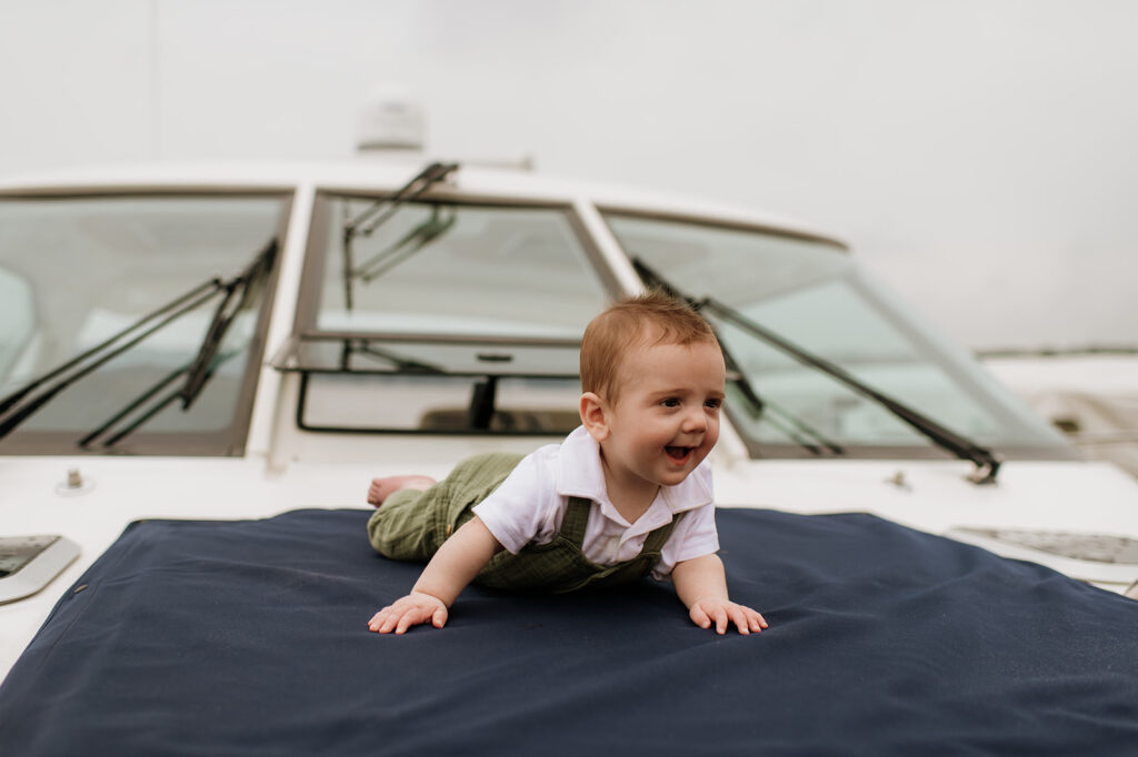 Baby laying on a boat during his Lake Michigan family photos with his parents