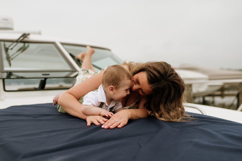 A mother laying with her baby on a big during their Lake Michigan family photos in Holland