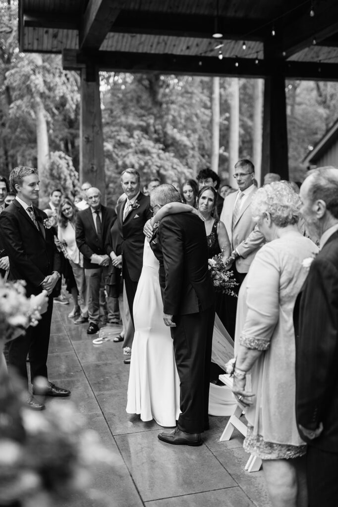 Black and white photo of a bride hugging her father