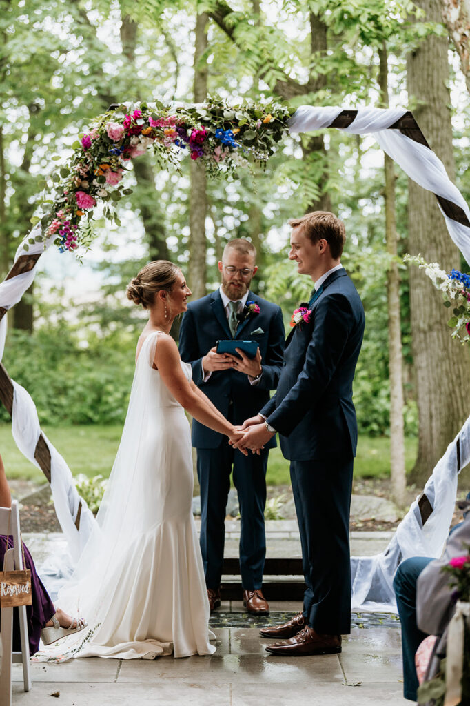 A rainy and colorful outdoor wedding ceremony on the Covered Patio at The Wooded Knot in Tippecanoe, Indiana