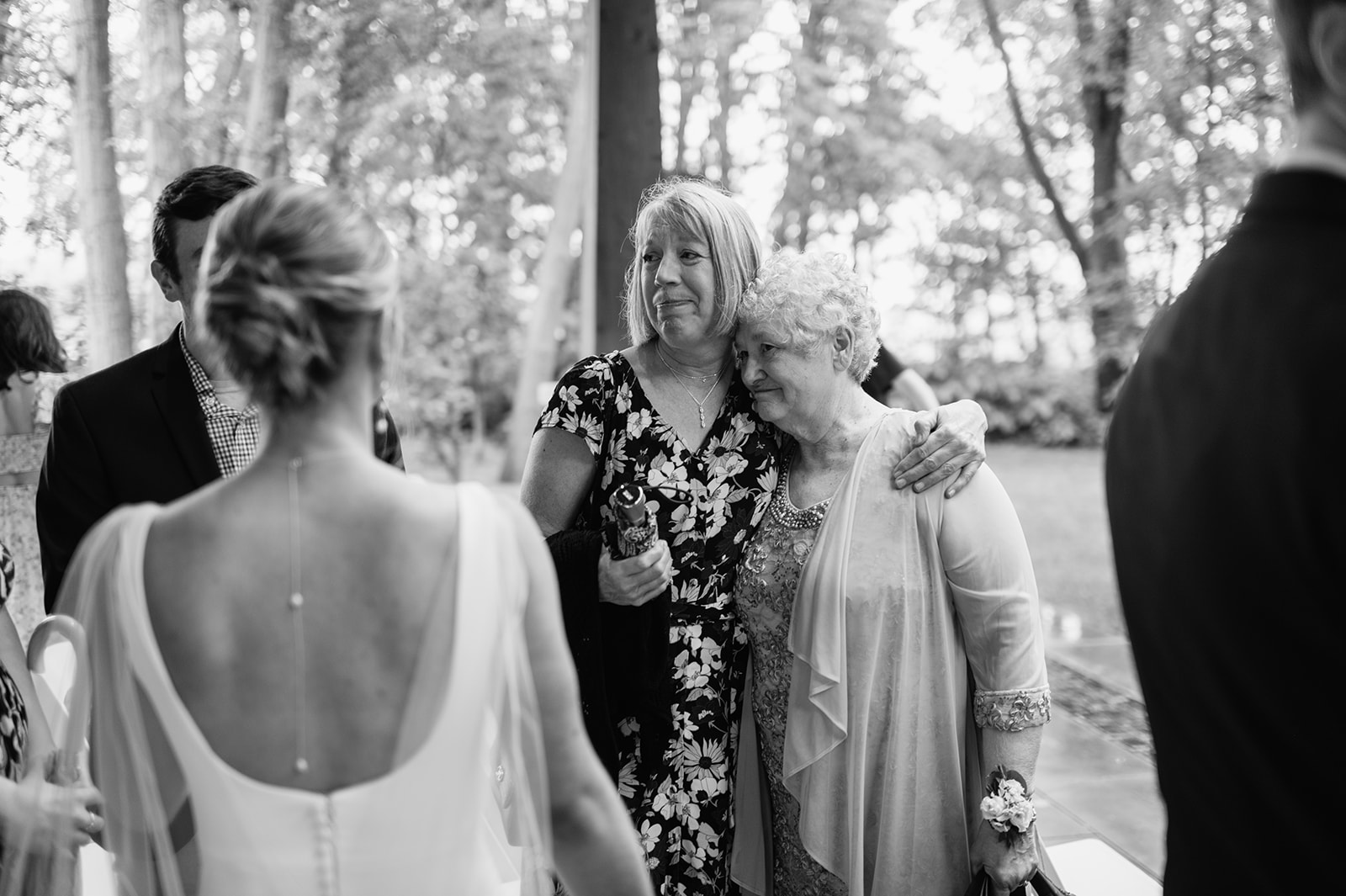 Black and white photo of a bride mingling with her family after their ceremony