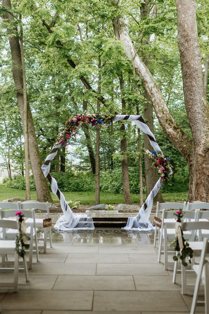 A rainy and colorful outdoor wedding ceremony on the Covered Patio at The Wooded Knot in Tippecanoe, Indiana