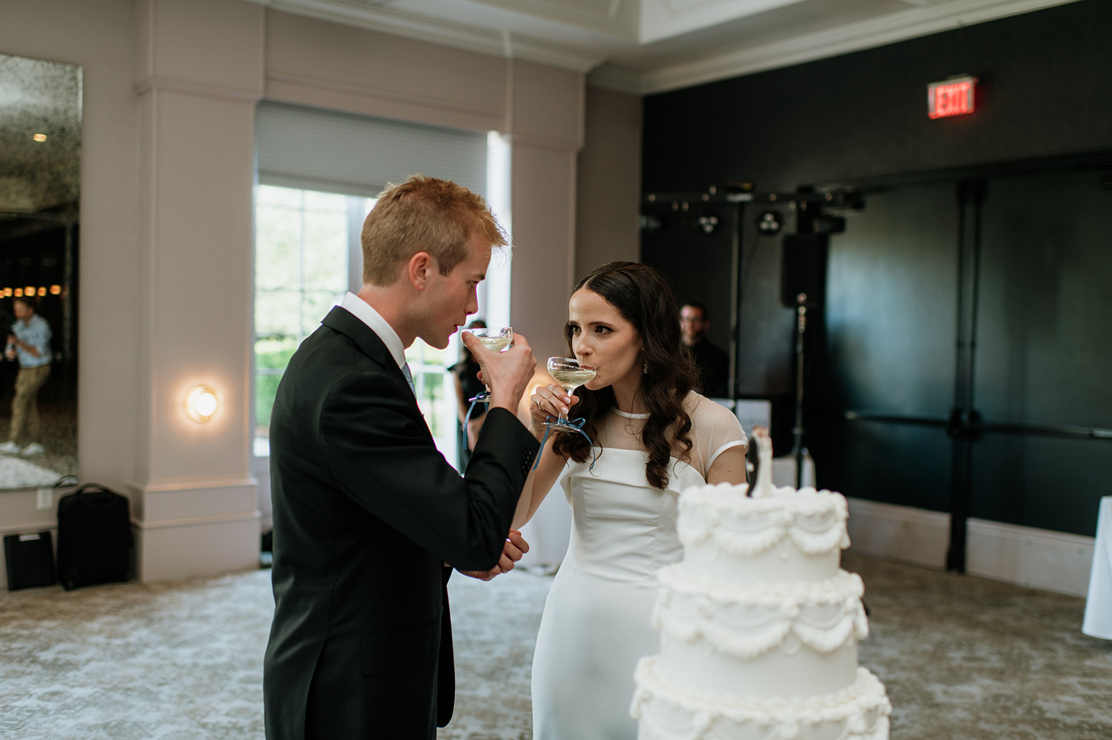 Bride and groom cutting into their wedding cake during their Ritz Charles Carmel, Indiana wedding reception in the Ginkgo Ballroom