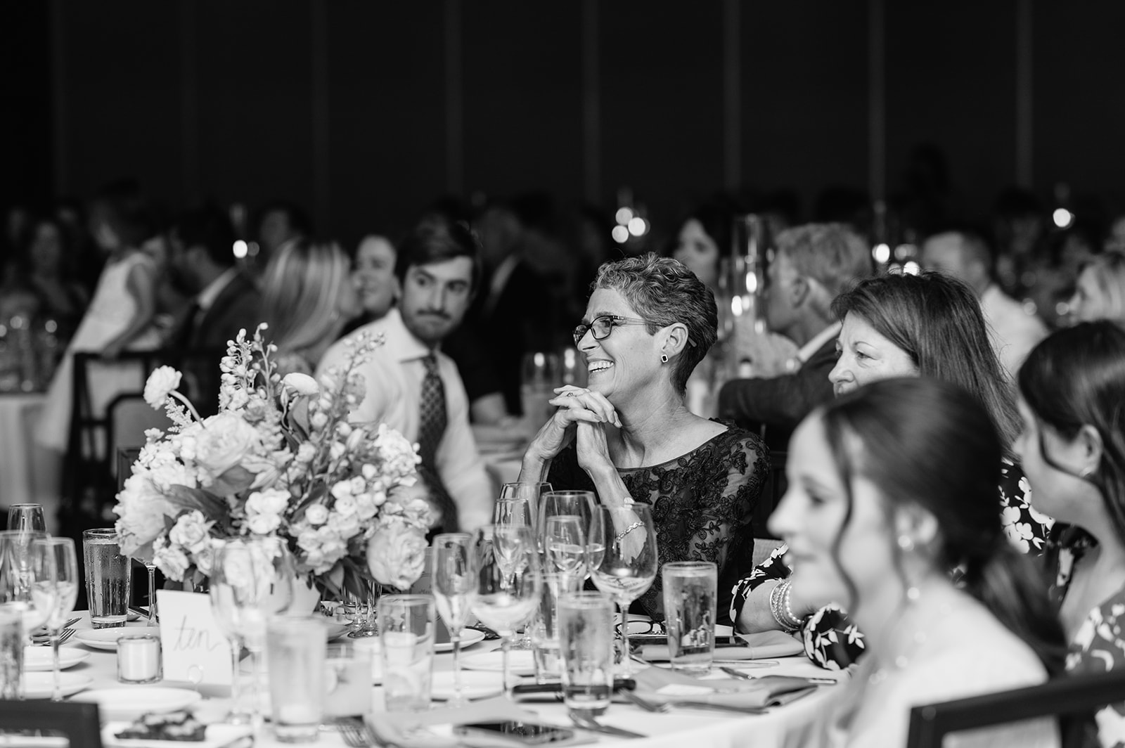 Black and white photo of wedding guests listening to speeches