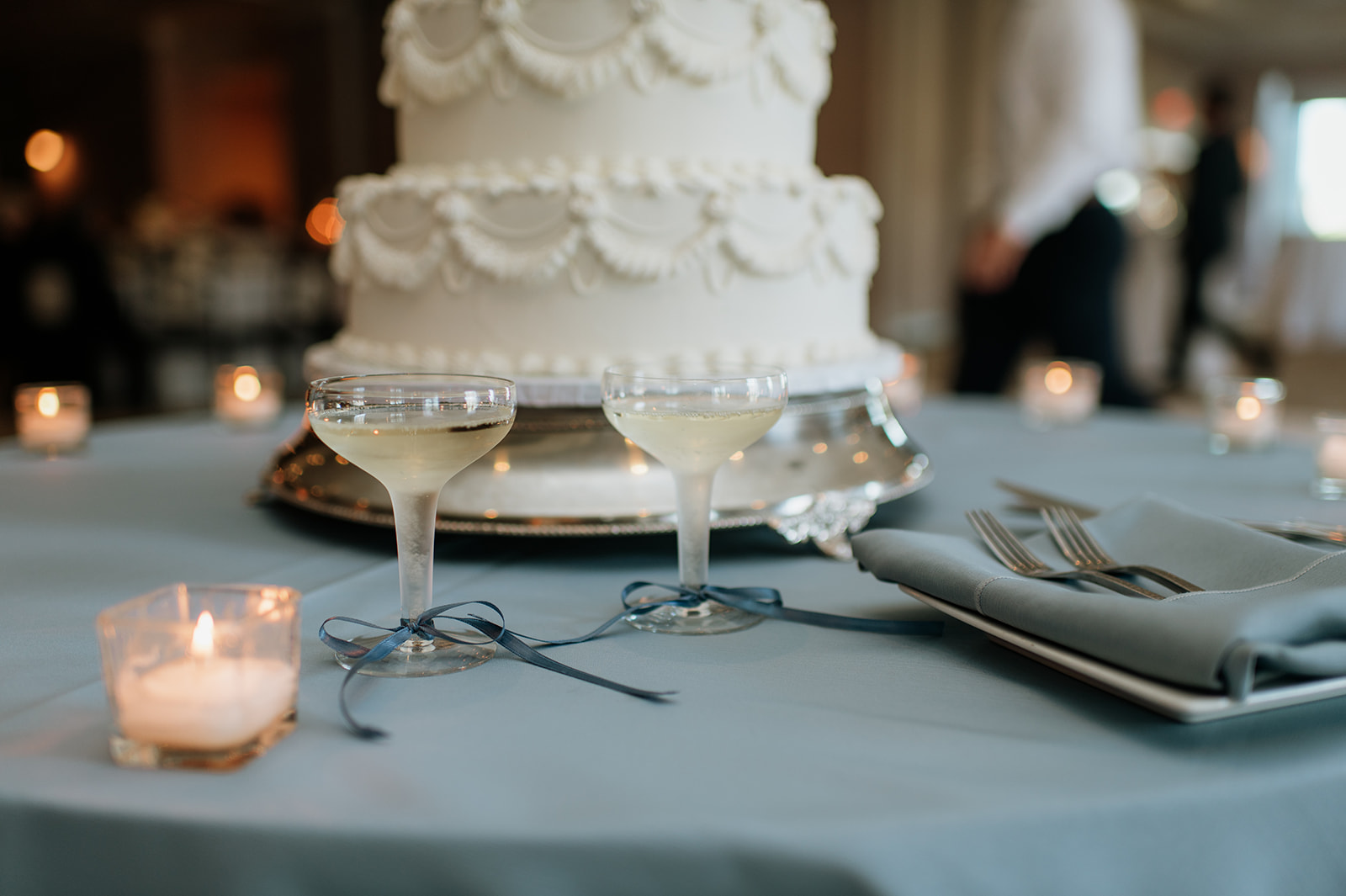 Champagne glasses next to a wedding cake