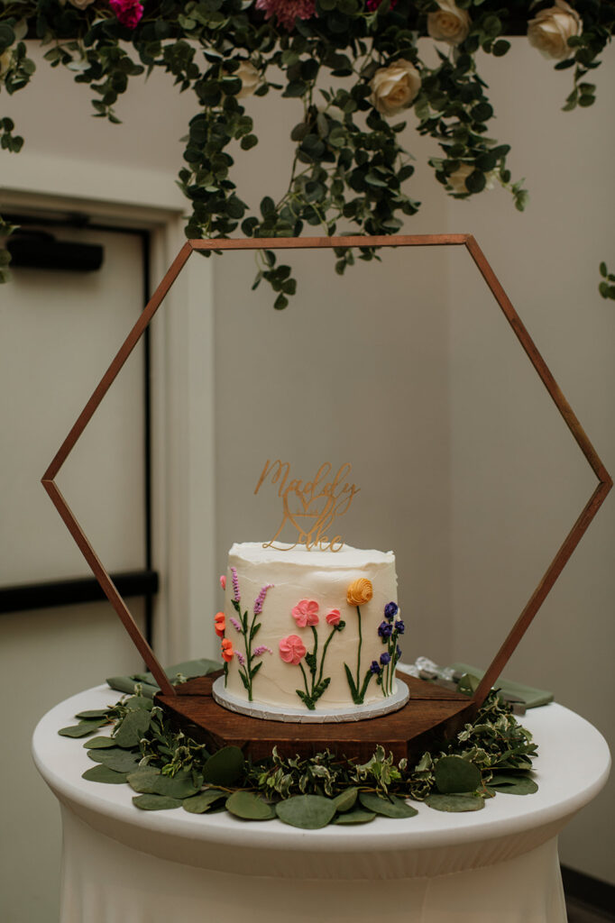 A simple flower wedding cake with the names Maddy and Luke