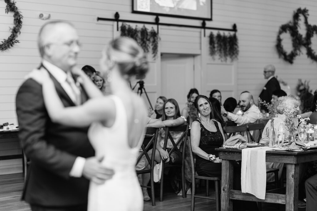 Black and white photo of a bride dancing with her father