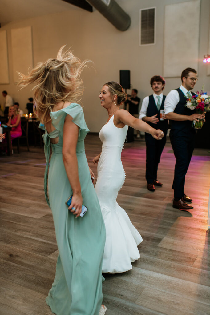 Bride dancing with her bridesmaid during the reception