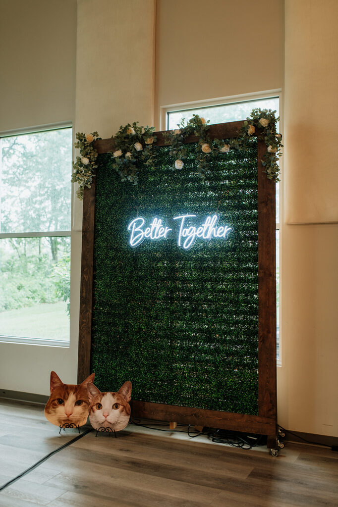 A wedding photo backdrop with a neon sign that says better together